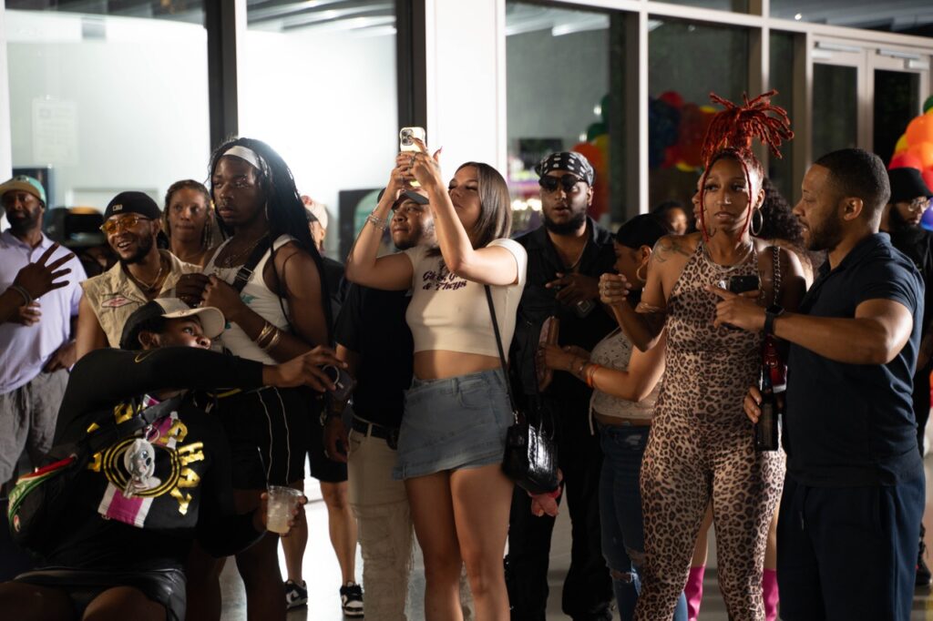 A group of people watch a performance at Pride and Joy.