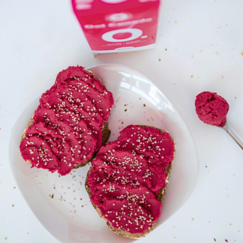 Two slices of toast with purple roasted beet hummus on top.