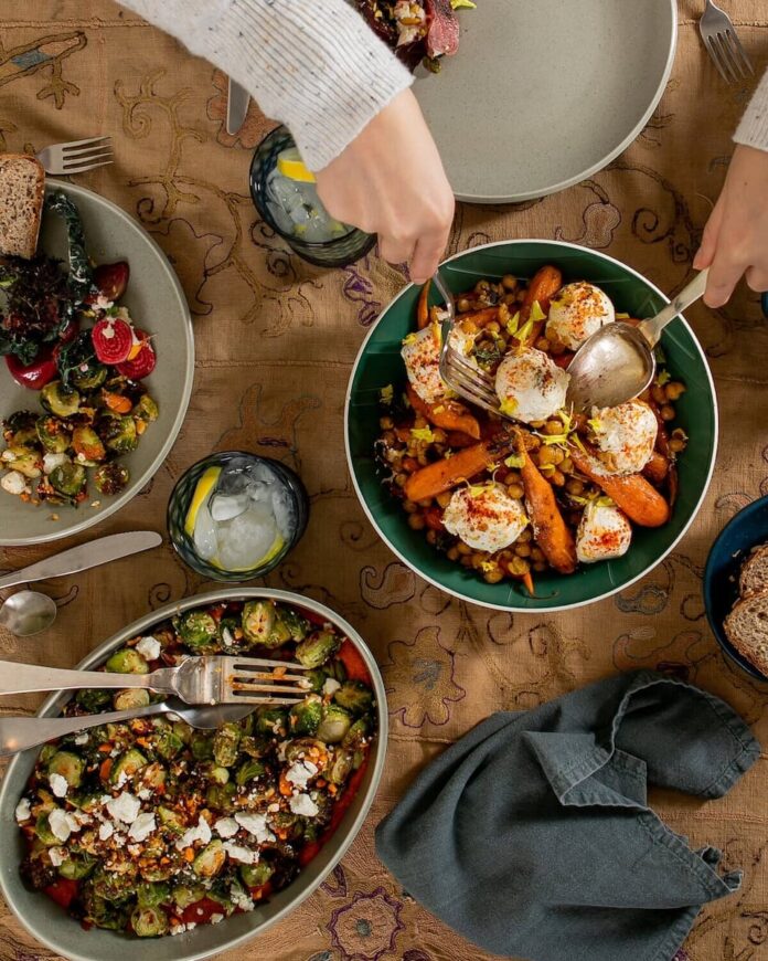 Roasted Brussels Sprouts with Romesco Sauce & Aged Feta served in a bowl.