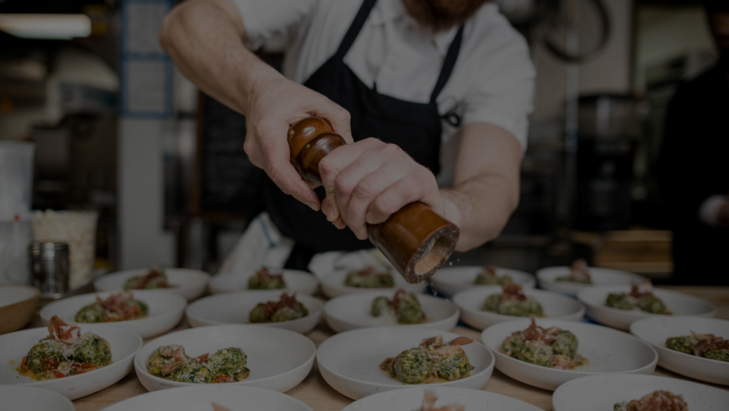 A man spices various white bowls.