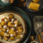 An aerial shot of Sweet Corn Semifreddo on a green plate. It is covered with a caramel drizzle and small pieces of corn. Semifreddo Recipe