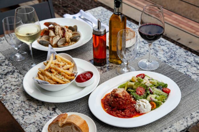 A table with several white dishes presenting different menu items available at Rivers Casino