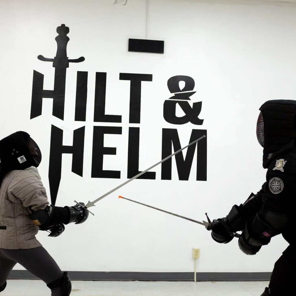 Two students at Hilt and Helm learning about fencing technique. 