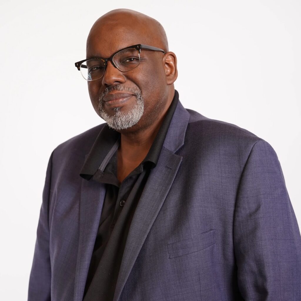 A man in a jacket on a white background, writing instructor Tony Norman.
