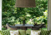 Brenda Friday Design Brings the Garden Inside A green sofa sits with green pattern pillows below a lamp shade chandelier.