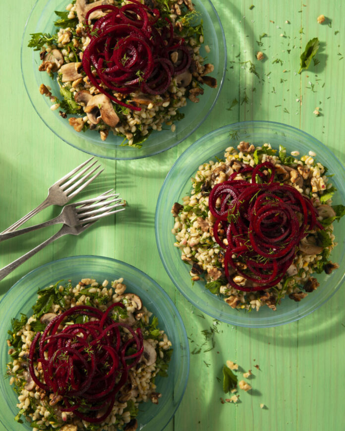 Barley Salad with Walnuts & Beet Ribbons Three clear plates hold Barley Salad with Walnuts and Beets on a green background