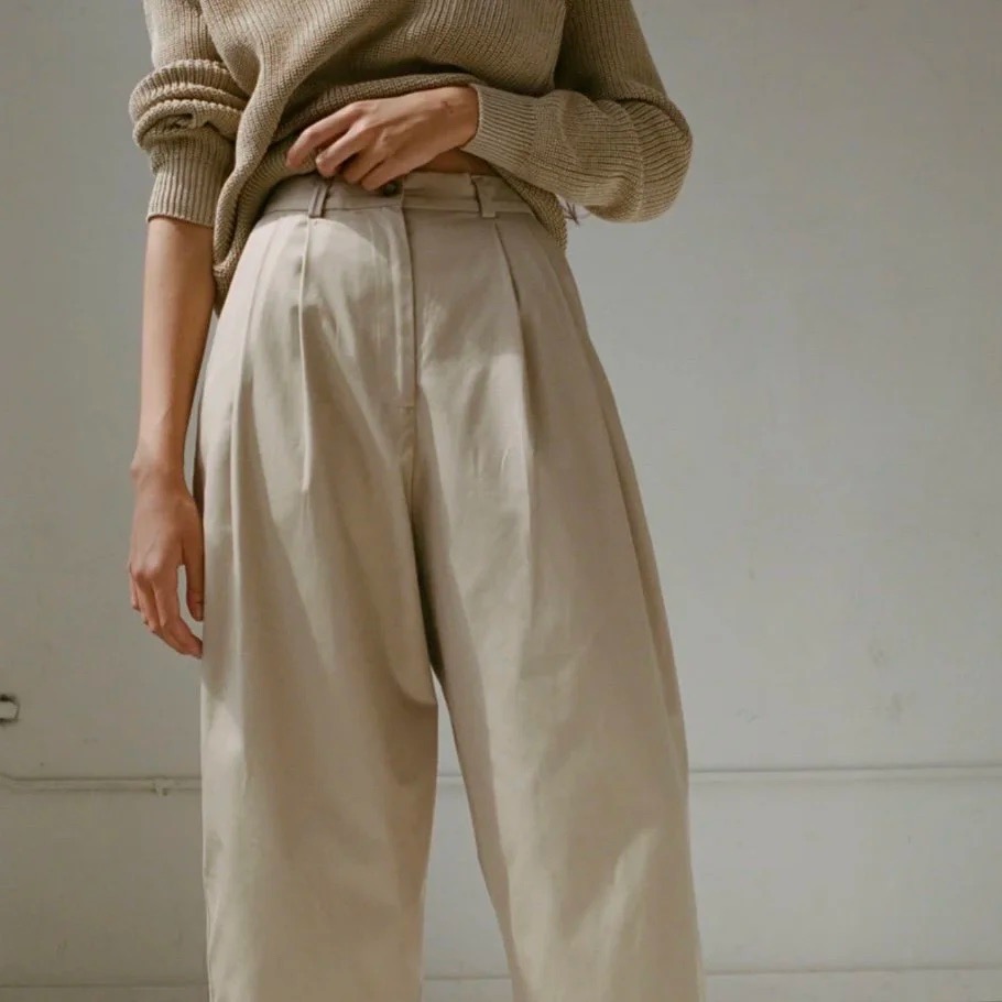 A person in slacks and an olive sweater.