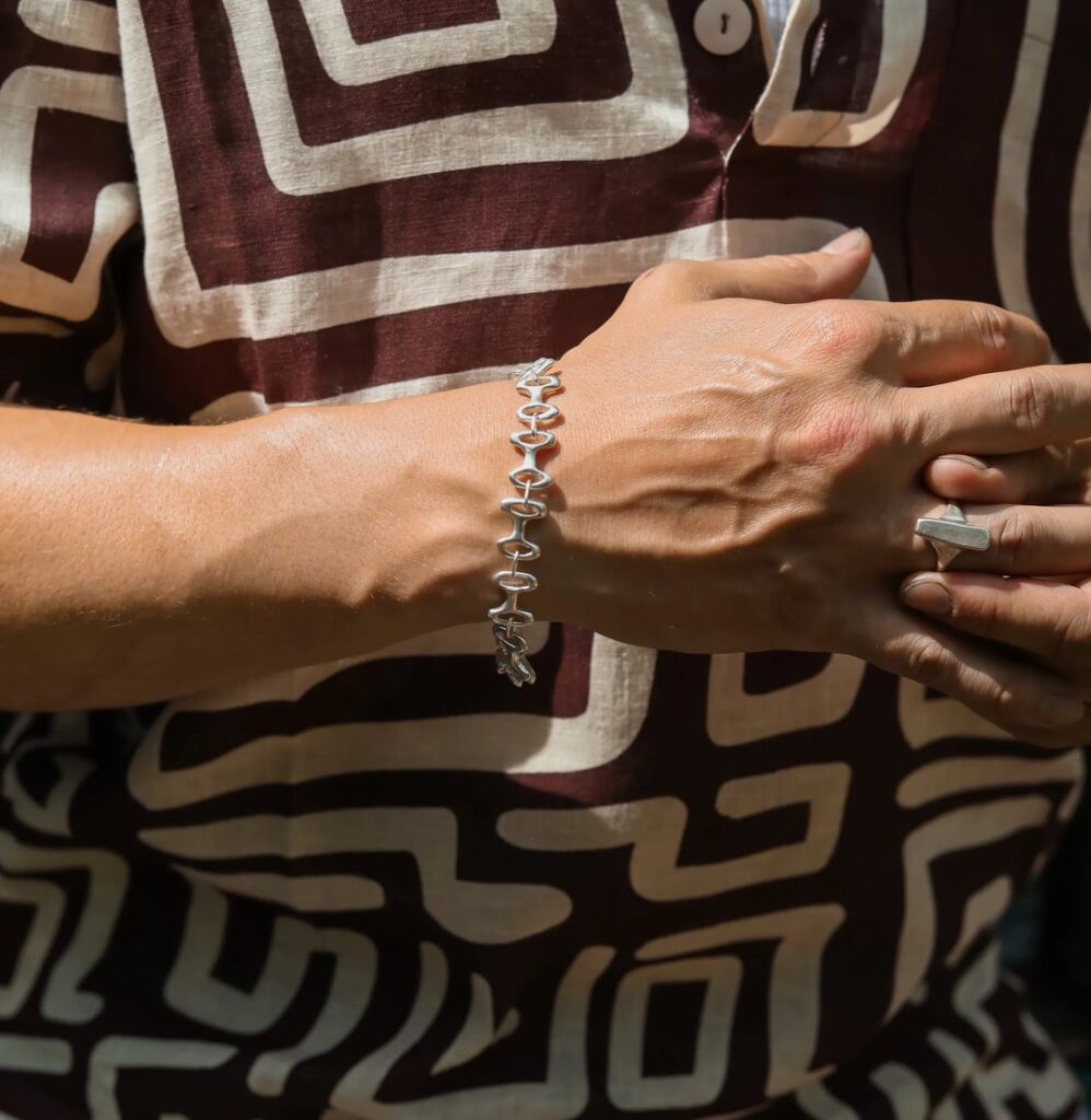 A man in a red pattern shirt and bracelet.