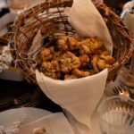 A basket full of filling (stuffing) balls on a dining table on top of a white napkin.