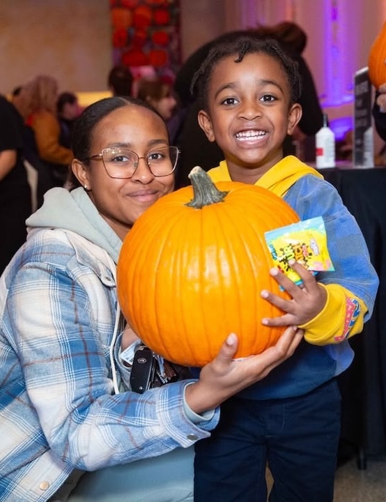 Family at Pittsburgh Halloween event with pumpkin.