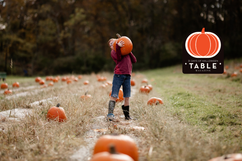 Child carrying a pumpkin at a Pittsburgh pumpkin patch