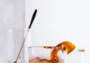 The Rye Cranhattan A glass of Rye Cranhattan on a table with ice, garnished with a cranberry and an orange peel.
