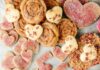 Whole-Grain Swedish Rye Cookies Heart-shaped and round cookies, some with a pink sugar dusting, arranged on a marble surface to spell out the word "LOVE" with individual letters.