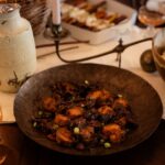 A brown plate of sweet potato rounds on a dinner table.
