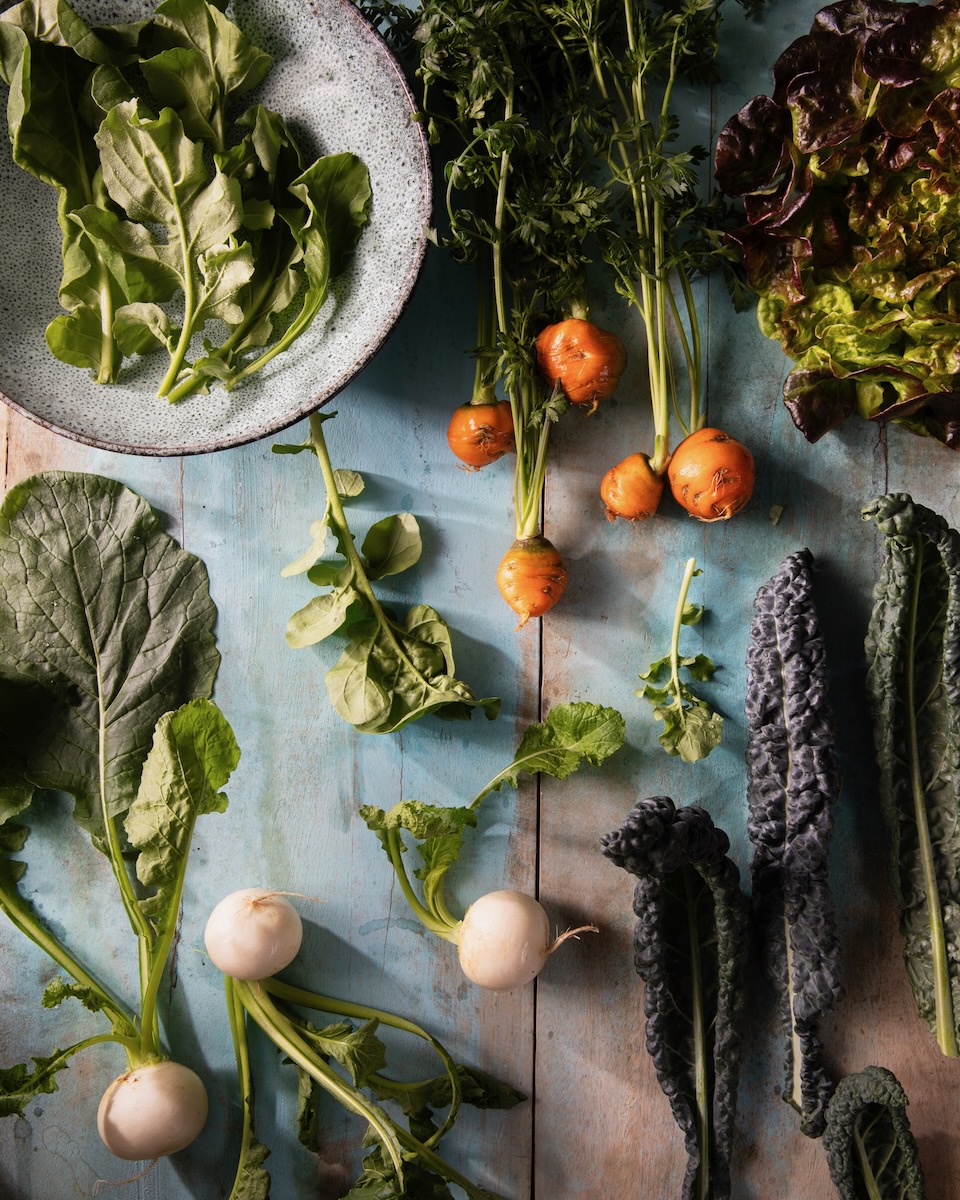Vegetables laid out before being put into a winter greens salad.