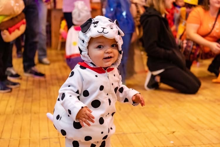 Baby in dalmatian costume at Pittsburgh Halloween event.