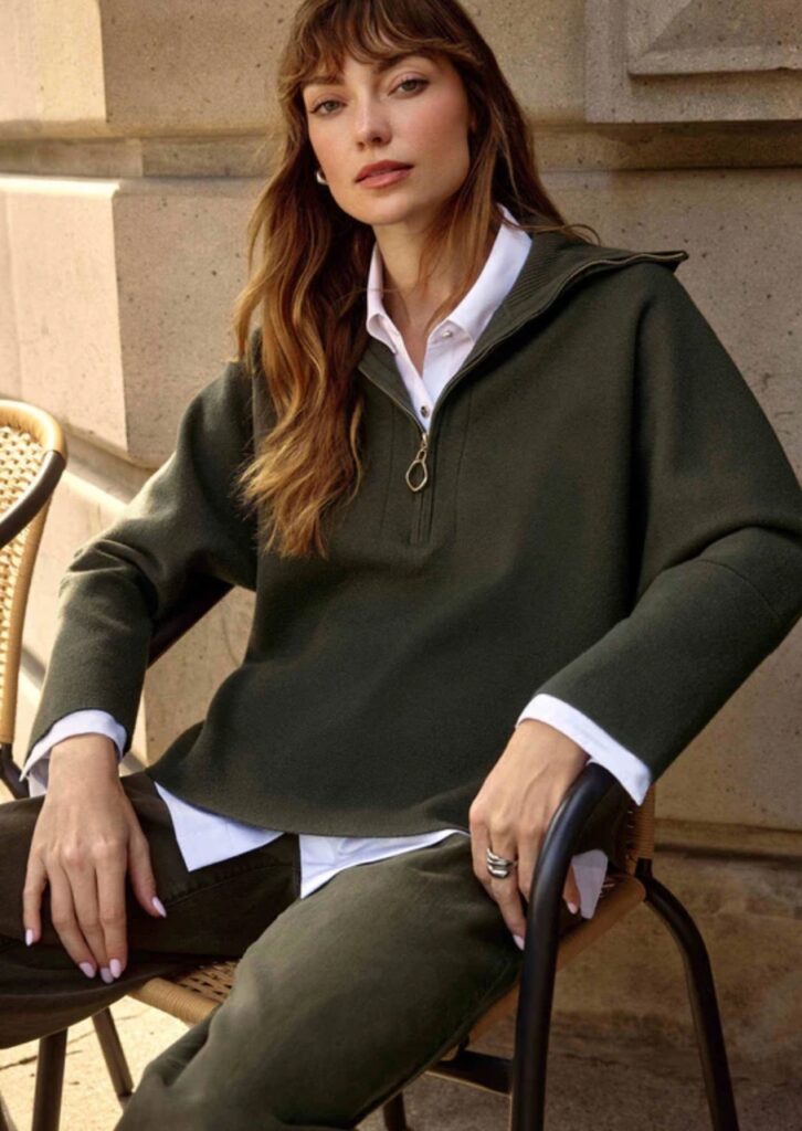 A woman in a fall jacket and blouse.