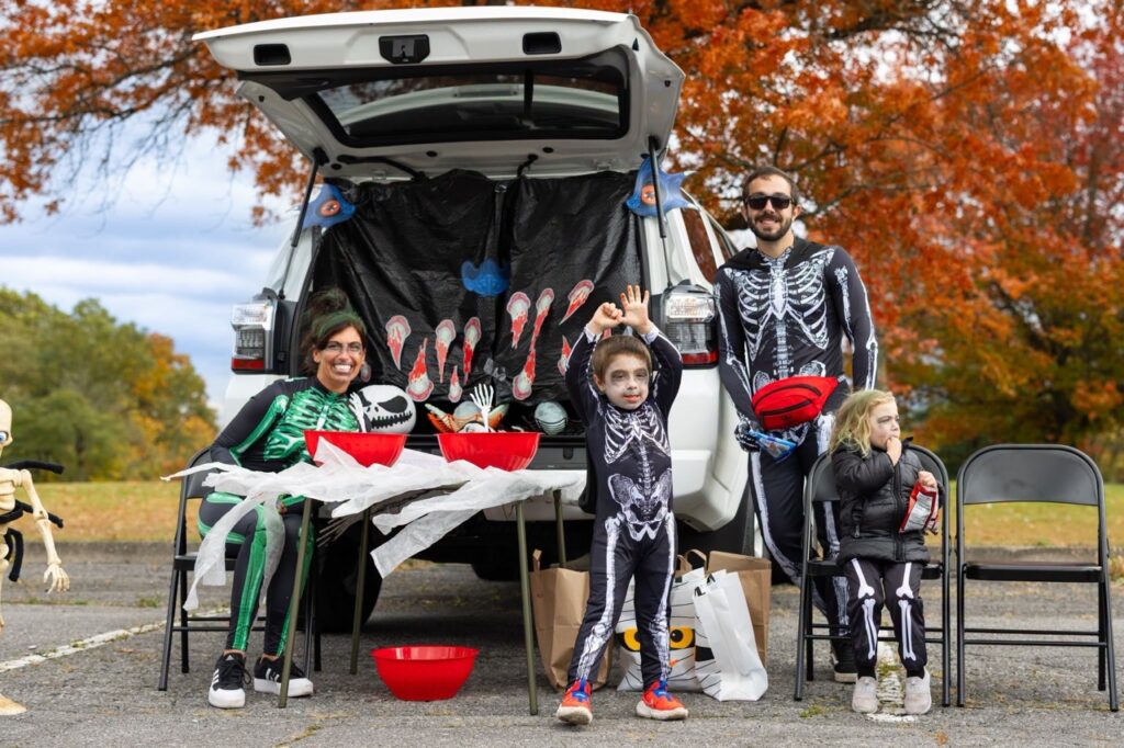 Family in skeleton costumes at a Pittsburgh Halloween trunk-or-treat event.