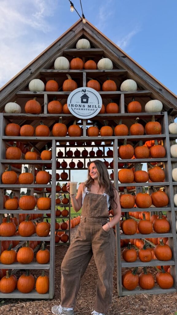 Woman in overalls at Irons Mill Farmstead pumpkin patch near Pittsburgh.