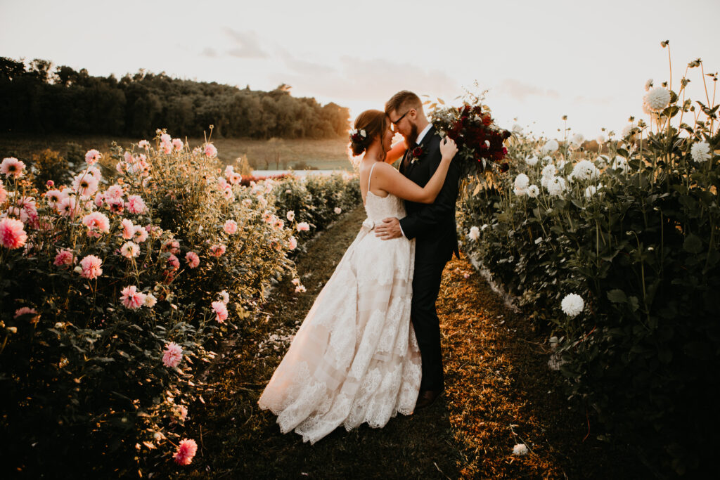bride and groom holding each other in flower field
