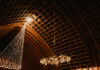 Love Designs a Rustic Wedding Inside and Out bride and groom dance in rustic ball room with fairy lights