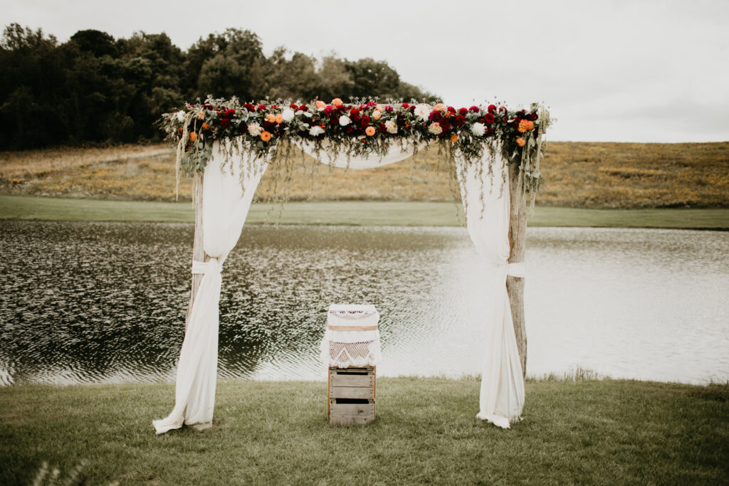wedding tapestry with flowers in front of water