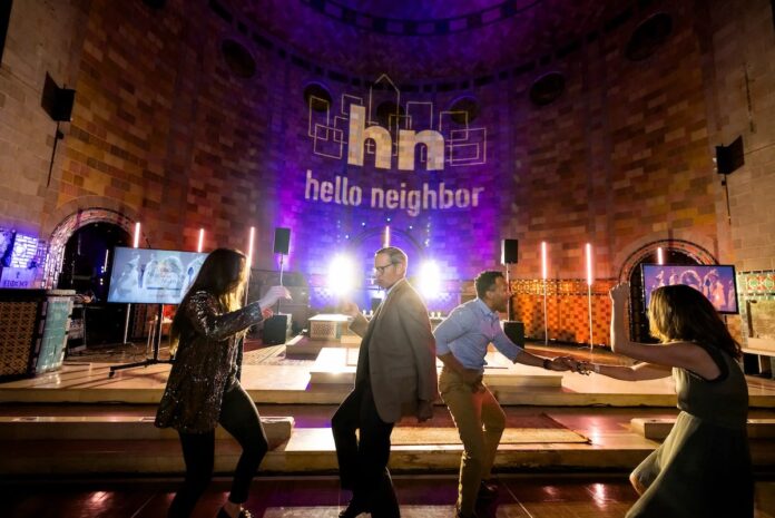 Hello Neighbor’s Neighborhood Nosh Will Put the Fun in Fundraiser Partygoers enjoy themselves in a dimly lit room for the Neighborhood Nosh at Hello Neighbor.