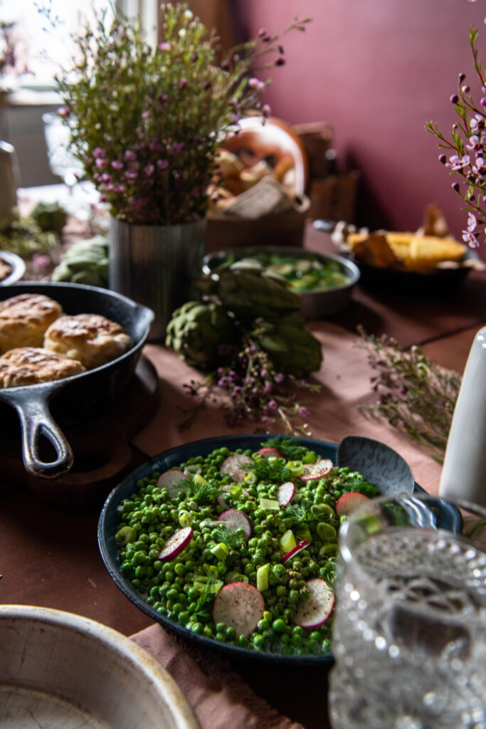 A table with a salad on it and a mauve wall in the background. 