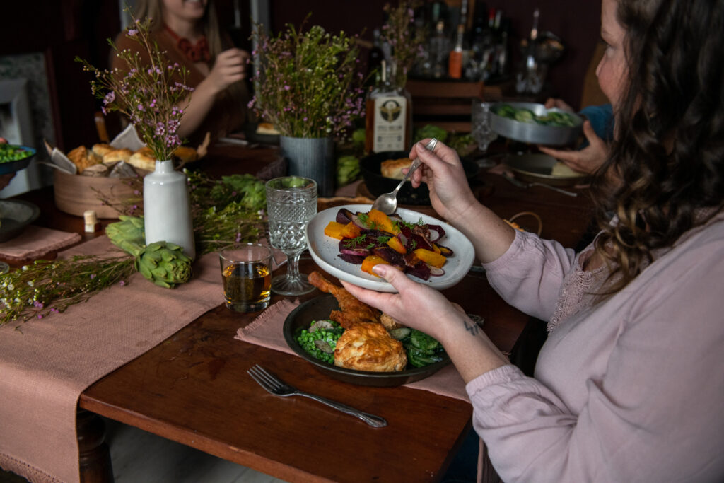 A woman eats from a plate at a dining table. 