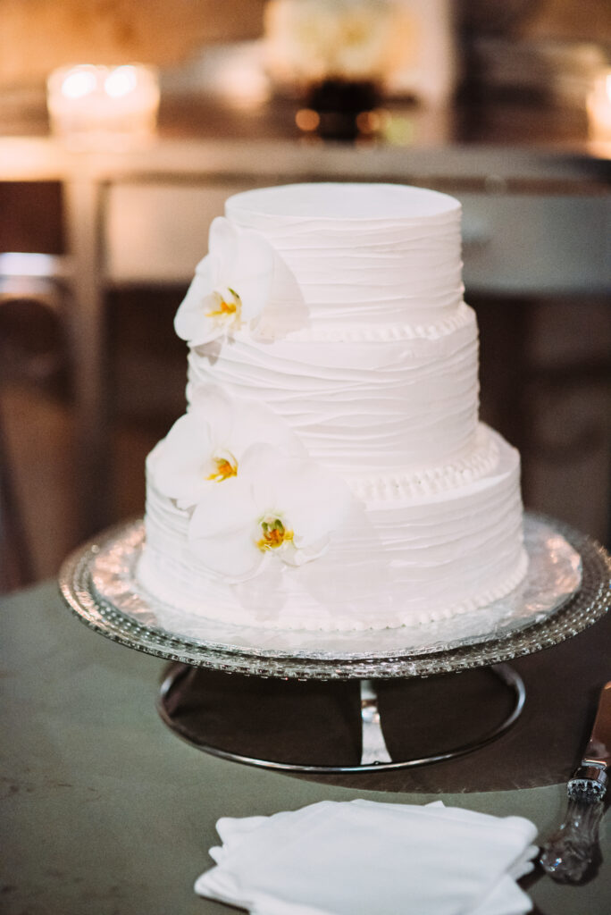 white cake with yellow flowers on top of silver tray