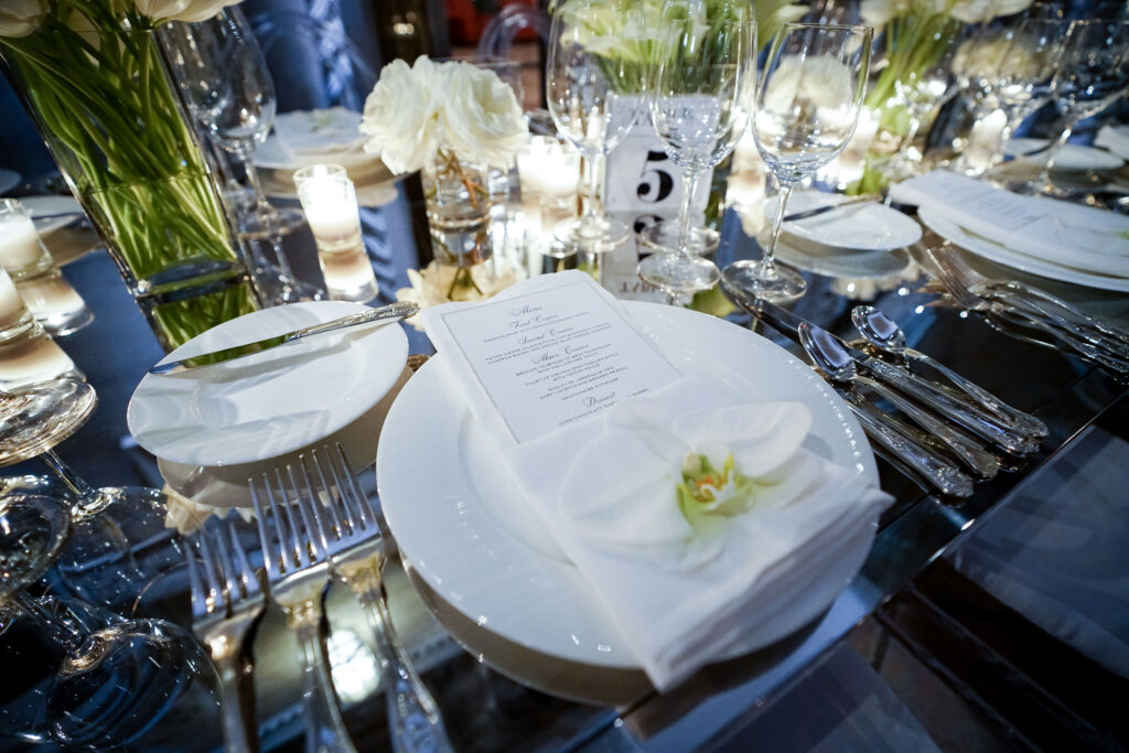 table with dining set up with white flowers and silverware