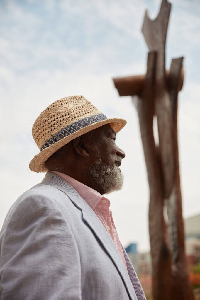 A man in a fedora hat outside of an art installation.