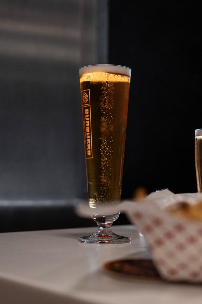 A glass of beer under a light.