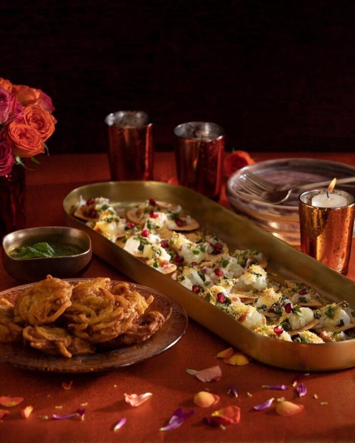 Diwali+Onion+Bhaji+and+Dahi+Papdi+Chaat+Recipe+TABLE+Magazine+Bryce Diwali Onion Bhaji and Dahi Papdi Chaat on gold serve ware with red accent decorations.
