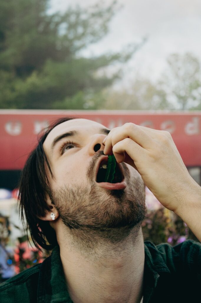 A man eating a gummy worm.