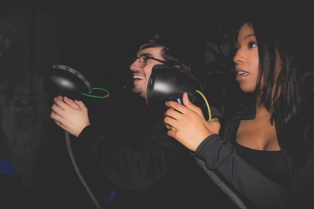 A man and woman hold blasters in their hands.