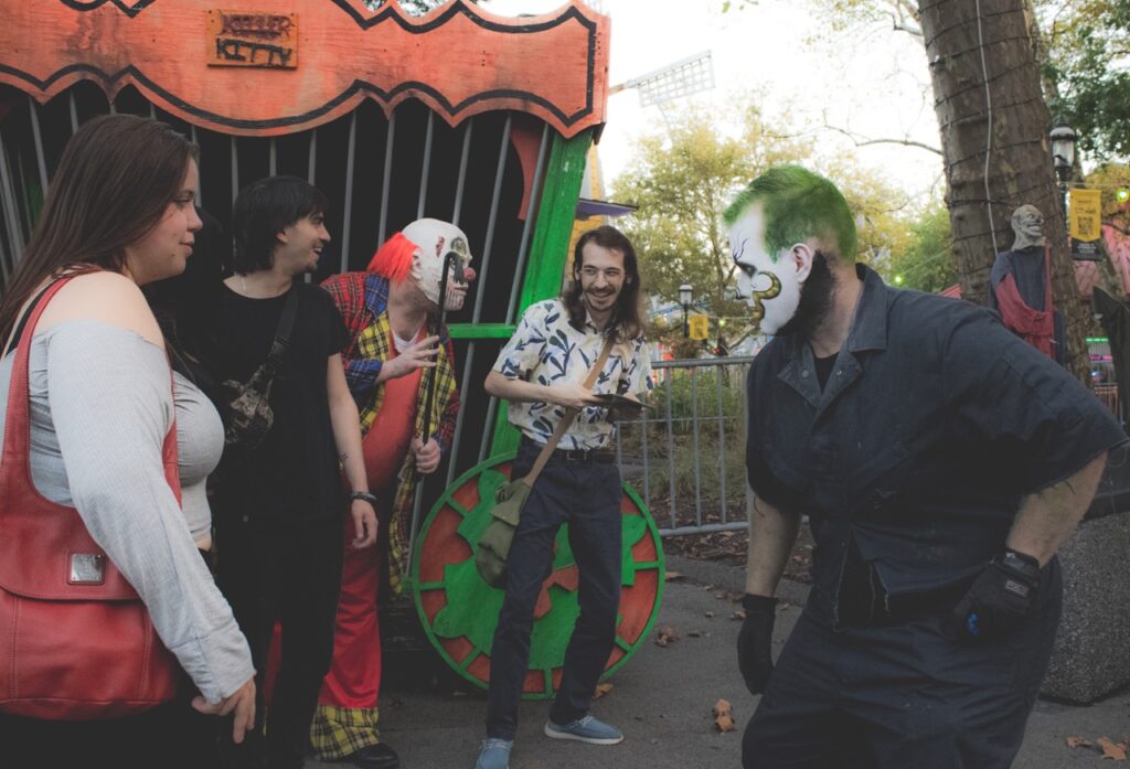 Two clowns in a group of park goers.