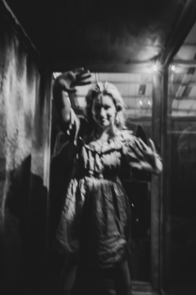 A marionette woman leans against her box.
