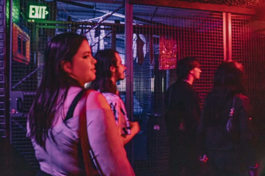 A group of people walk along cage doors.