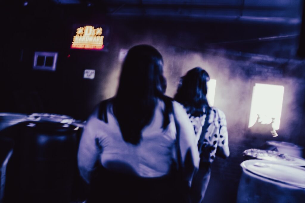 Two people walking through a smokey entry way.