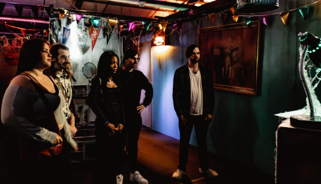 A group of people stand in an office space area of a haunted house.