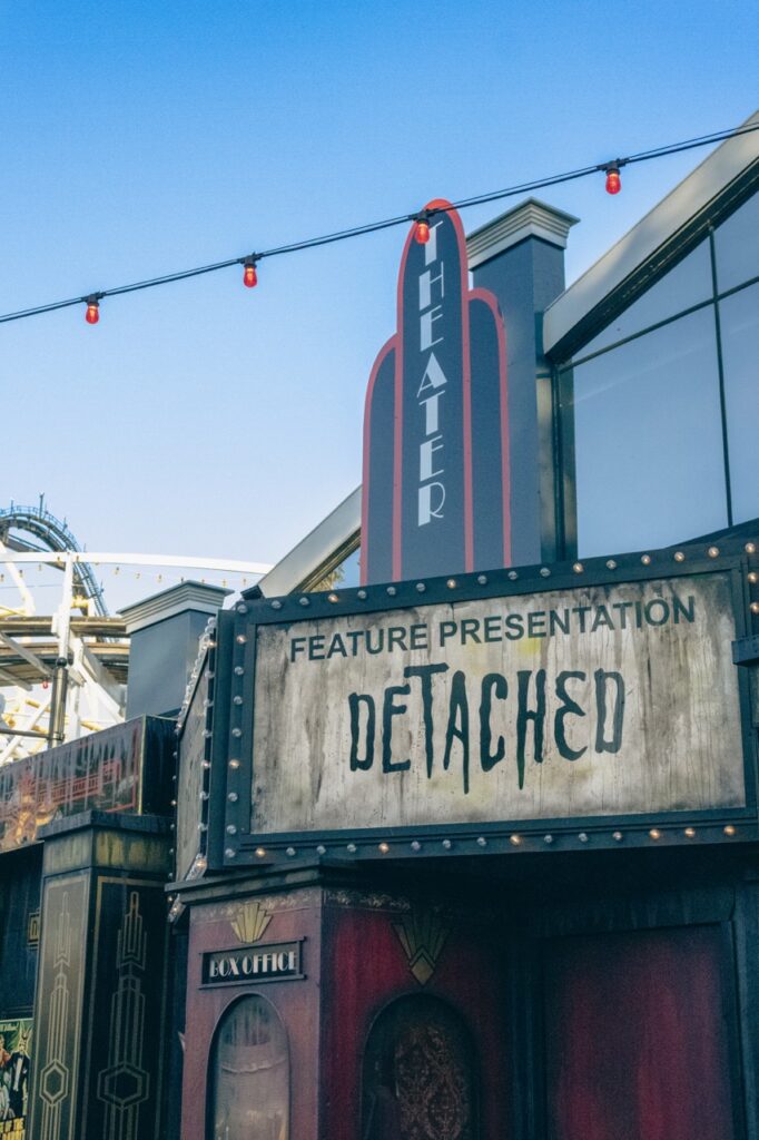 The outside of Detached haunted house with a marquise sign. 