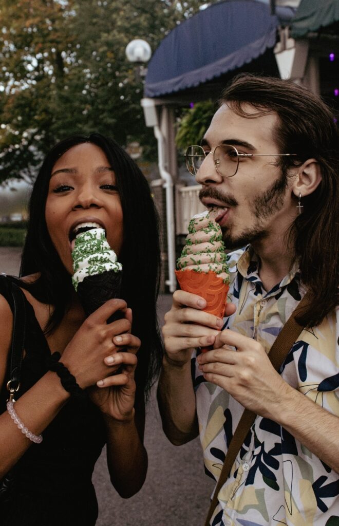 Two people eat black and orange ice cream cones.