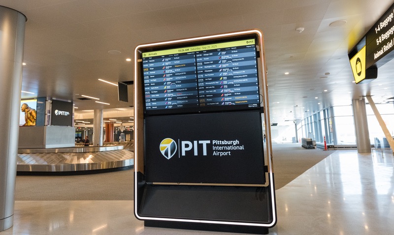 The Pittsburgh Airport terminal with flight times on a large board.