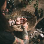 Woman with tattoo'd arms fixing a garnish over a bowl