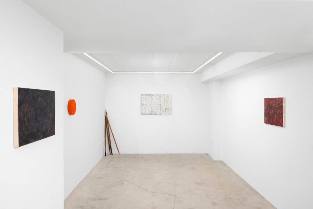 An art gallery room with white walls and an art piece on each.