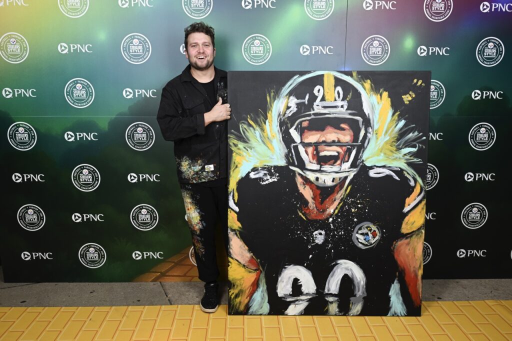 A painter next to a painting of Steelers player 90, TJ Watt.