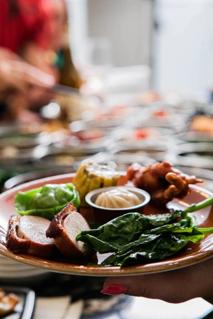 A variety of dim sum dishes, including pork belly, dumplings, and steamed greens.