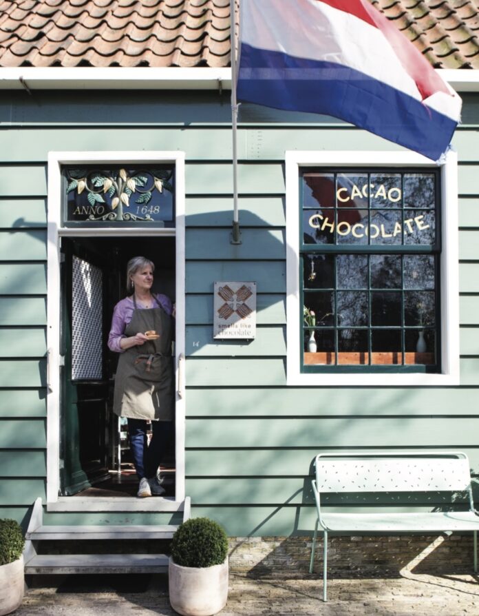 smells like chocolate 1 lady looking out blue chocolate shop doors