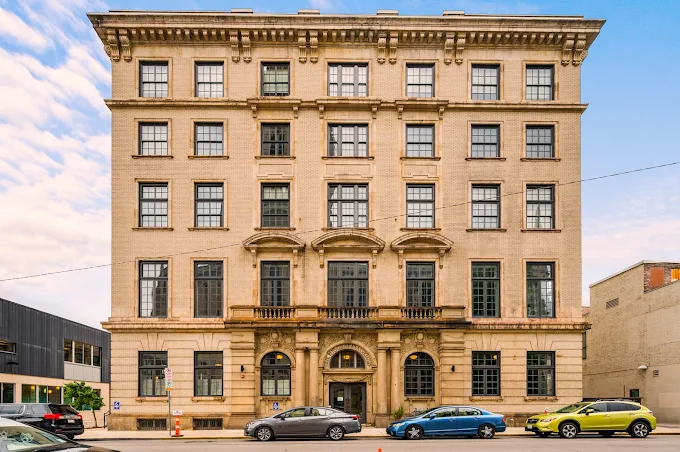 A pale building outside on a blue sky background.